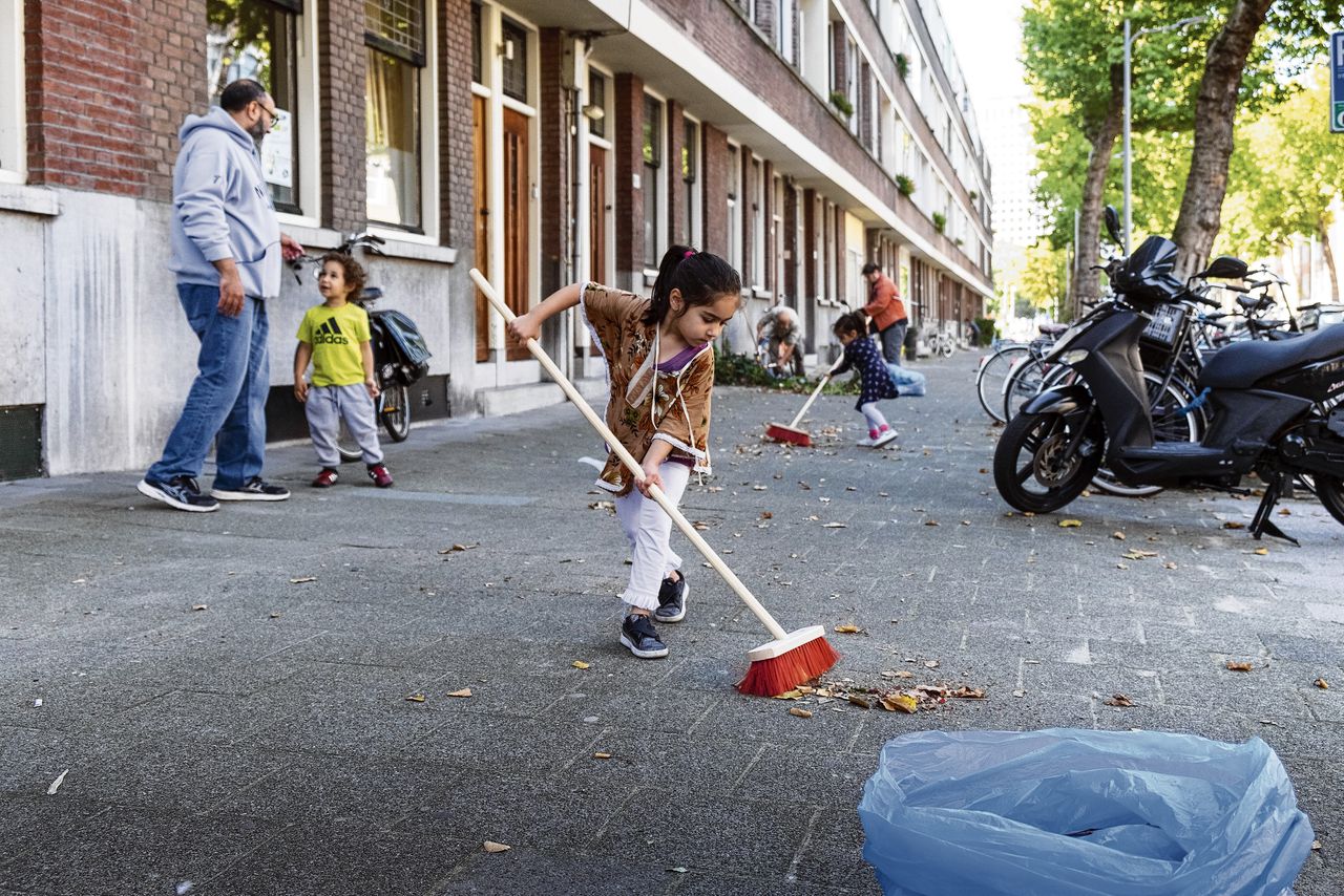 Buurtbewoners die samen de straat opruimen